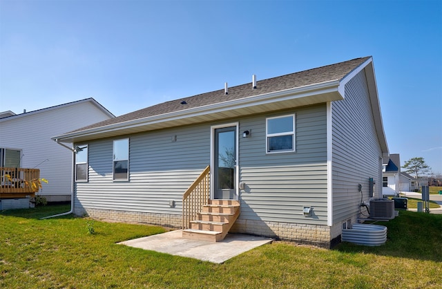 back of property with central AC unit, a yard, and a patio area