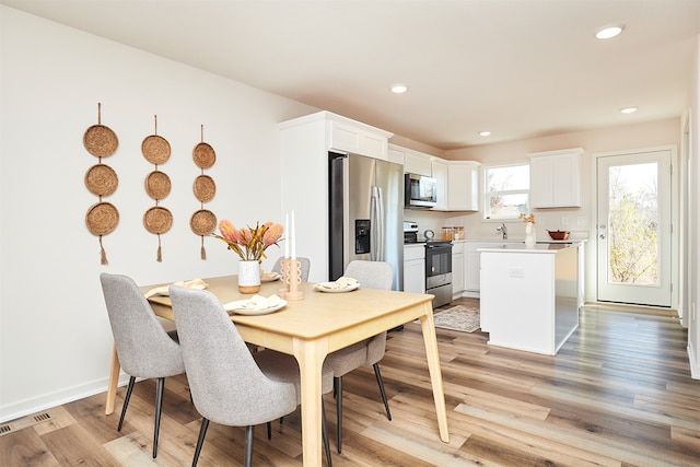 dining space featuring sink and light hardwood / wood-style flooring