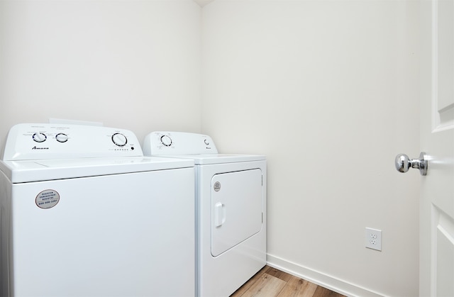 laundry room featuring washing machine and clothes dryer and light wood-type flooring