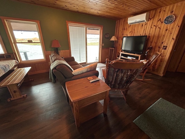 living room with plenty of natural light, dark hardwood / wood-style floors, an AC wall unit, and wooden walls