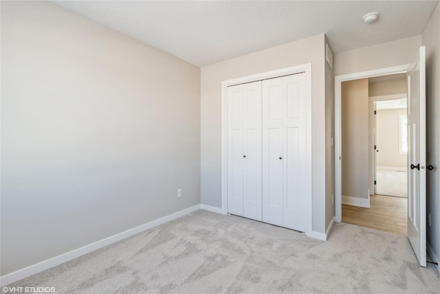 unfurnished bedroom featuring a closet, carpet flooring, and baseboards