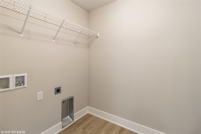 clothes washing area with hookup for a washing machine, light wood-style flooring, hookup for an electric dryer, laundry area, and baseboards