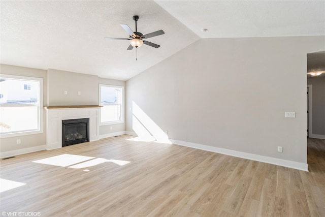 unfurnished living room with baseboards, vaulted ceiling, light wood finished floors, and ceiling fan