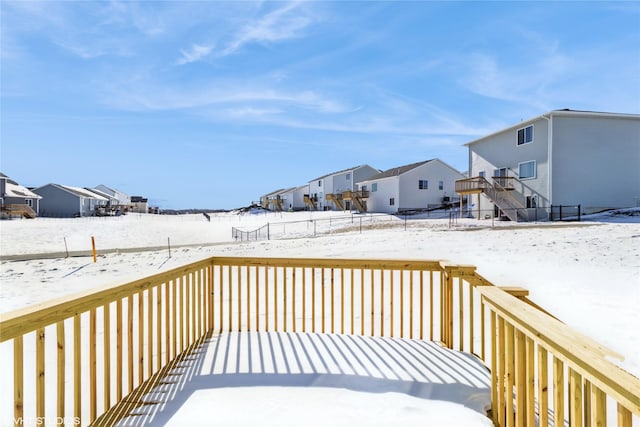 snow covered deck featuring fence and a residential view