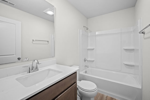 full bath with visible vents, toilet, tub / shower combination, vanity, and wood finished floors