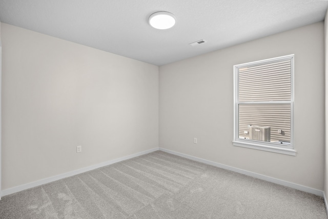 unfurnished room featuring baseboards, visible vents, and light colored carpet