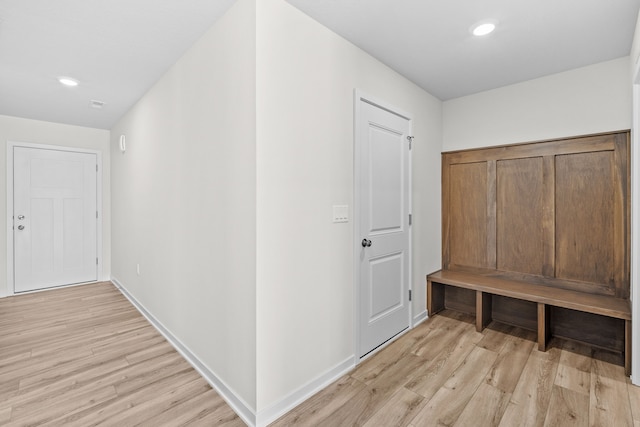 hallway with light wood finished floors, baseboards, and recessed lighting