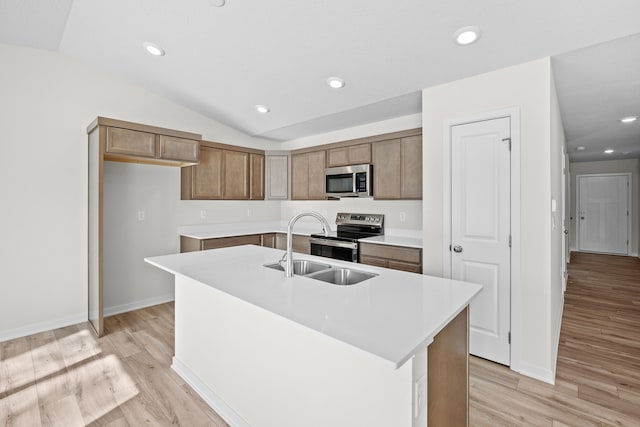 kitchen featuring brown cabinets, a kitchen island with sink, appliances with stainless steel finishes, and light countertops