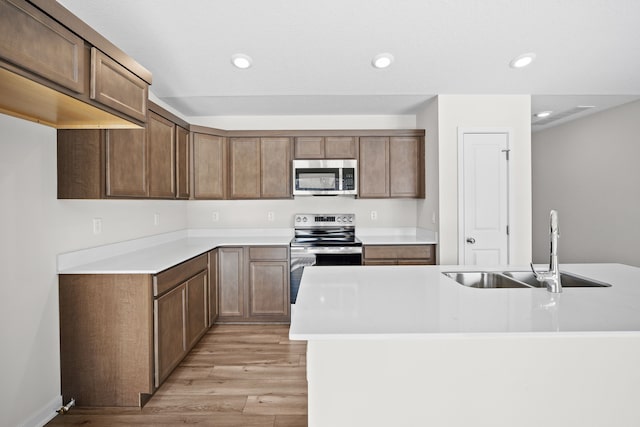 kitchen with a sink, stainless steel appliances, and light countertops