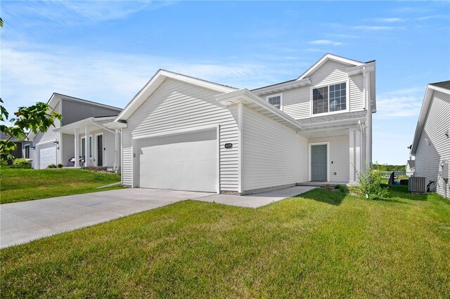 view of front of home with a garage, cooling unit, and a front lawn