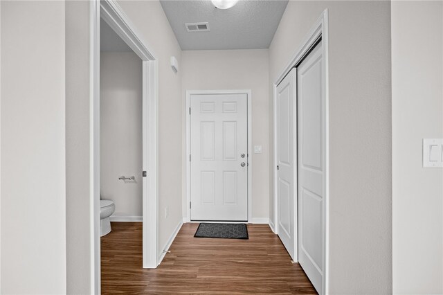 corridor featuring hardwood / wood-style flooring and a textured ceiling