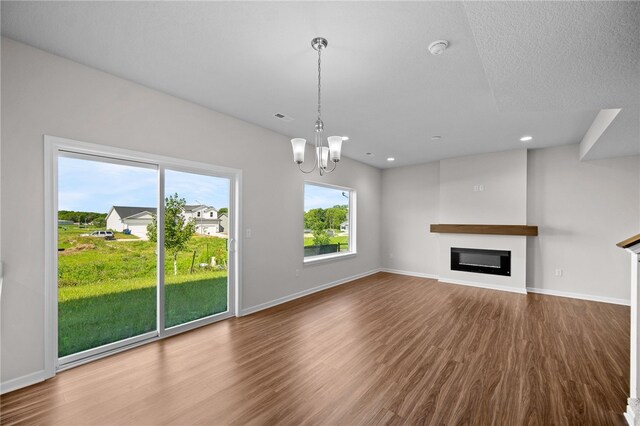 unfurnished living room featuring hardwood / wood-style floors and a chandelier