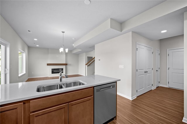 kitchen with hardwood / wood-style floors, dishwasher, sink, and hanging light fixtures