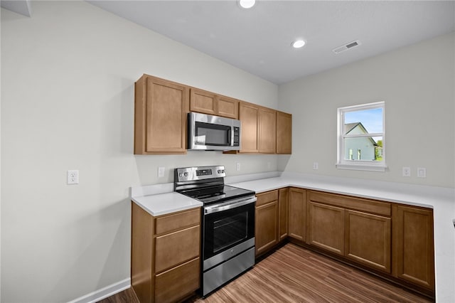 kitchen featuring appliances with stainless steel finishes and dark hardwood / wood-style flooring