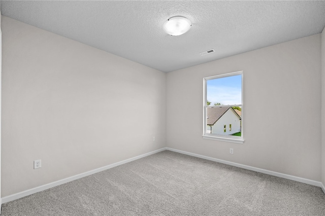 unfurnished room with carpet flooring and a textured ceiling