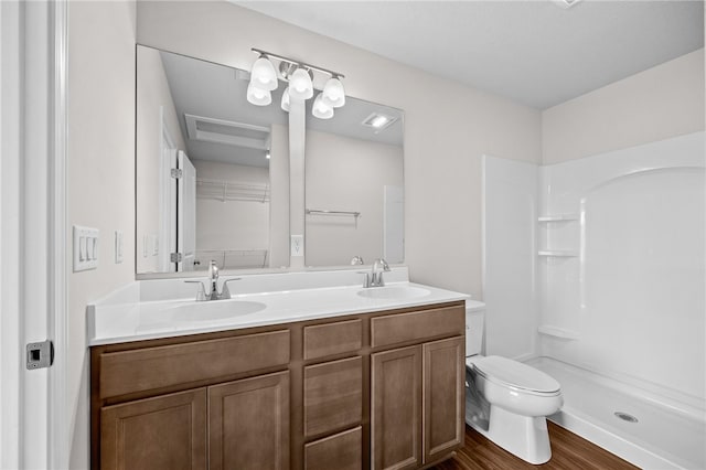 bathroom featuring toilet, hardwood / wood-style floors, vanity, and walk in shower