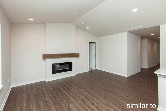 unfurnished living room featuring dark hardwood / wood-style flooring and vaulted ceiling