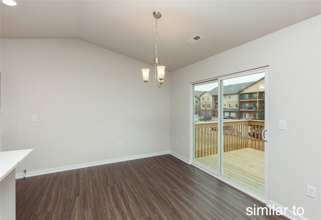 unfurnished dining area featuring a chandelier, dark hardwood / wood-style flooring, and vaulted ceiling