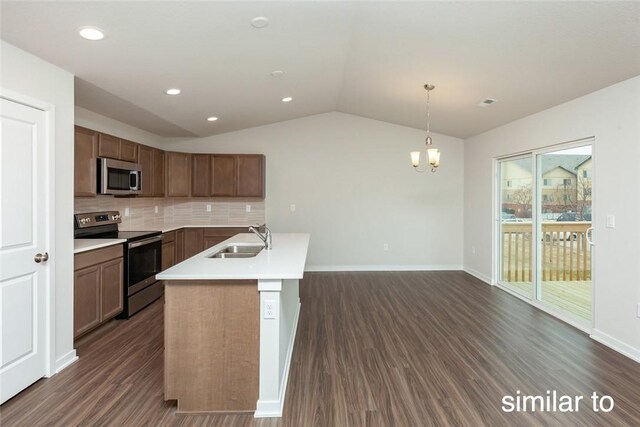 kitchen with appliances with stainless steel finishes, dark hardwood / wood-style flooring, vaulted ceiling, sink, and pendant lighting