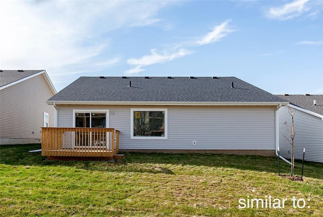 rear view of house with a wooden deck and a yard