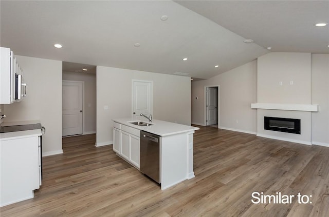 kitchen featuring sink, light hardwood / wood-style flooring, appliances with stainless steel finishes, white cabinetry, and a center island with sink