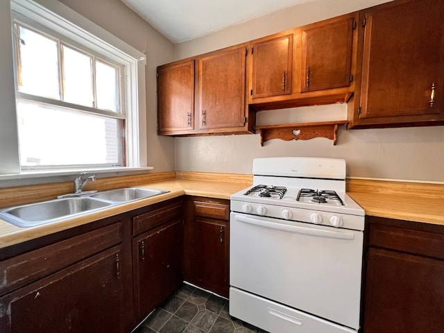 kitchen with white gas range and sink