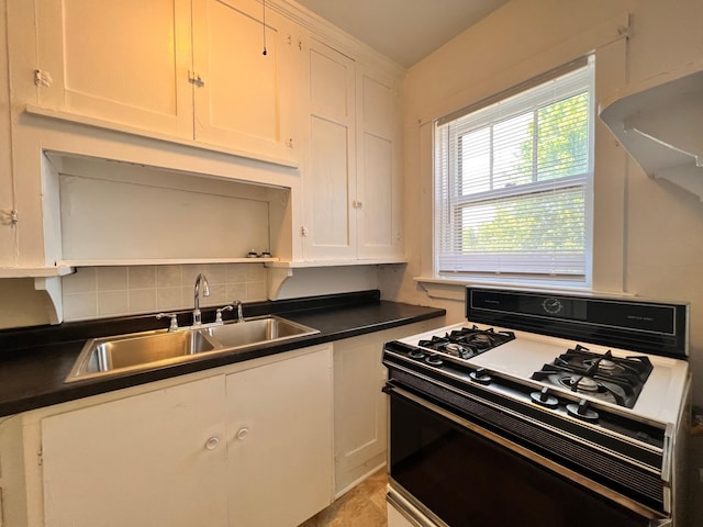 kitchen with white cabinetry, tasteful backsplash, sink, and white gas stove