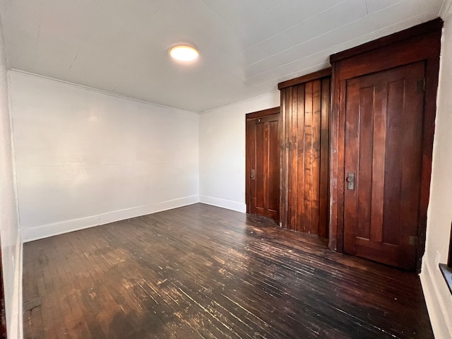 unfurnished bedroom with dark hardwood / wood-style flooring