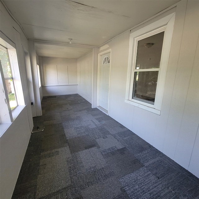 hall featuring dark colored carpet