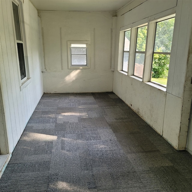 unfurnished room featuring dark colored carpet