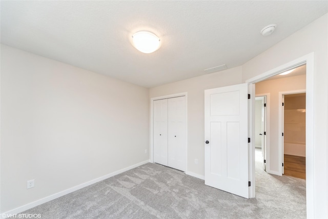 unfurnished bedroom featuring carpet floors, a closet, and baseboards