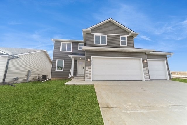 view of front of home with driveway, stone siding, an attached garage, and a front yard