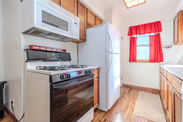 kitchen with light hardwood / wood-style flooring and white appliances