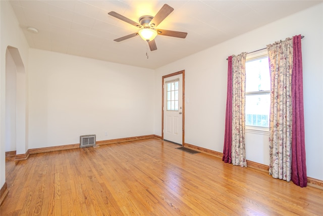 empty room with light hardwood / wood-style flooring, a healthy amount of sunlight, and ceiling fan