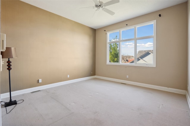 empty room with ceiling fan and light carpet