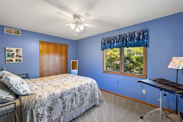 bedroom featuring a textured ceiling, carpet, ceiling fan, and a closet