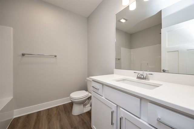 bathroom featuring toilet, vanity, hardwood / wood-style flooring, and walk in shower