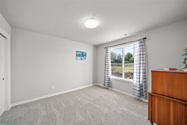 unfurnished bedroom with carpet floors and a textured ceiling