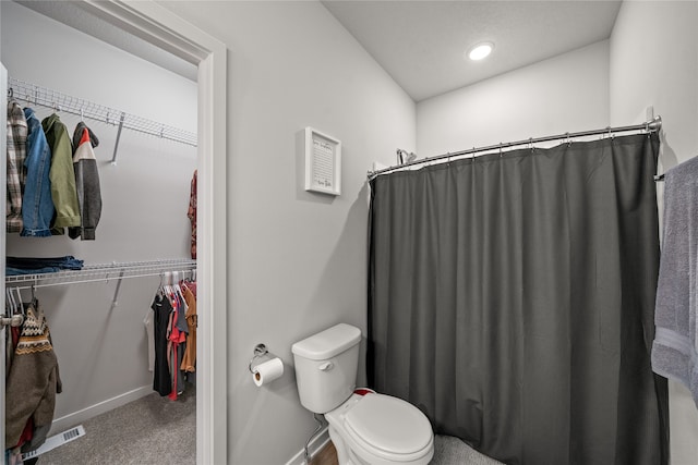 bathroom featuring walk in shower and toilet