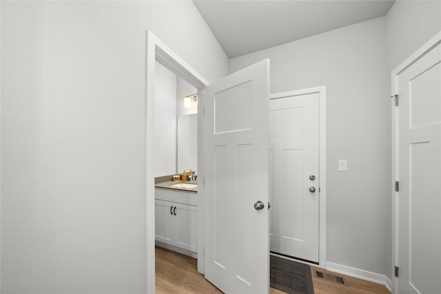 bathroom with hardwood / wood-style floors, vanity, and a textured ceiling