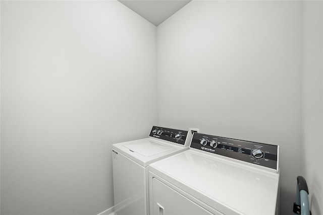 clothes washing area with washing machine and dryer