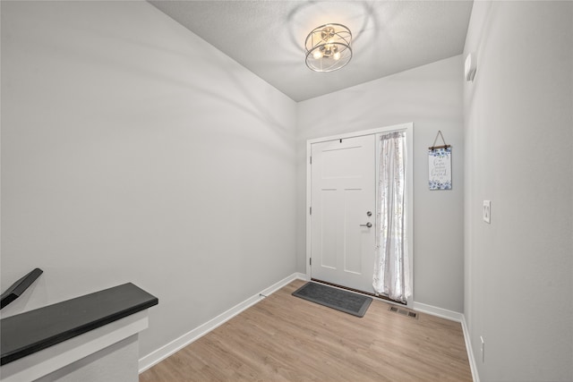 entryway featuring light wood-type flooring and a textured ceiling