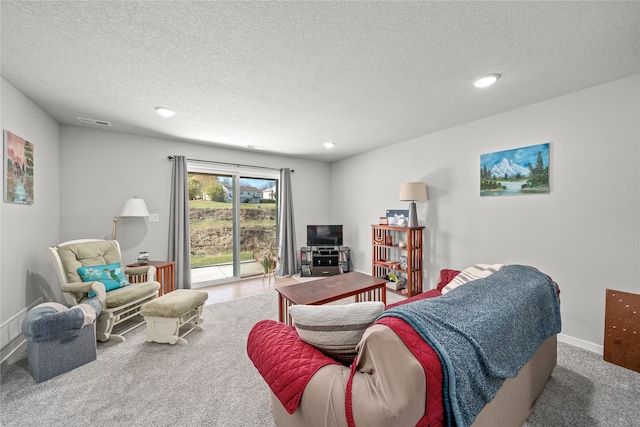 carpeted living room featuring a textured ceiling