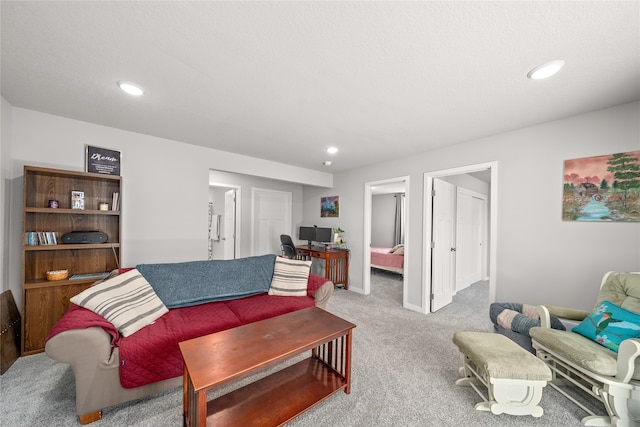 living room with a textured ceiling and light colored carpet