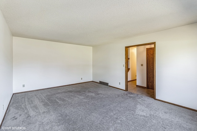 empty room featuring a textured ceiling and carpet floors