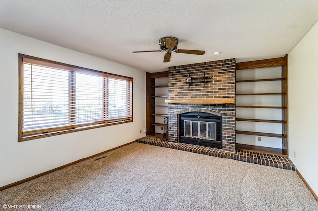 unfurnished living room with a fireplace, ceiling fan, a textured ceiling, and dark colored carpet