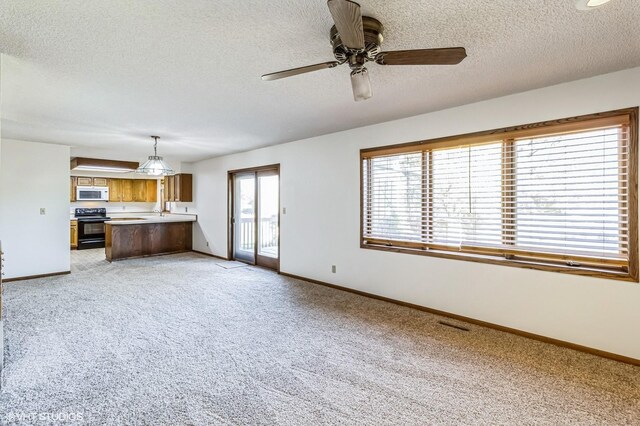 unfurnished living room with light colored carpet, a textured ceiling, and ceiling fan