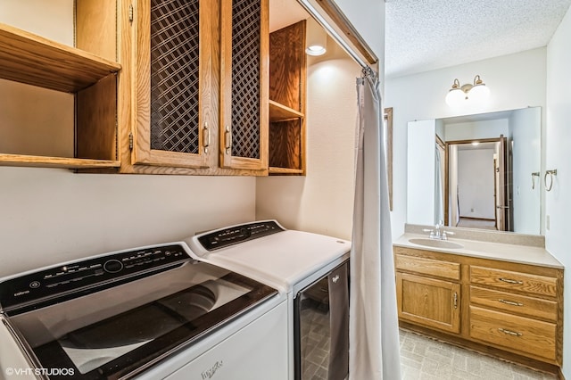 washroom featuring a textured ceiling, sink, and independent washer and dryer