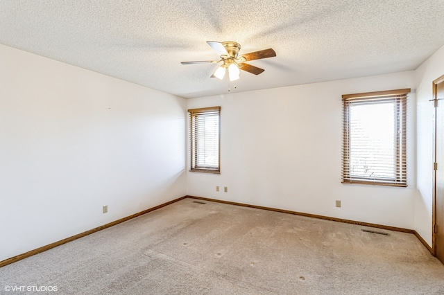 carpeted spare room with a textured ceiling and ceiling fan