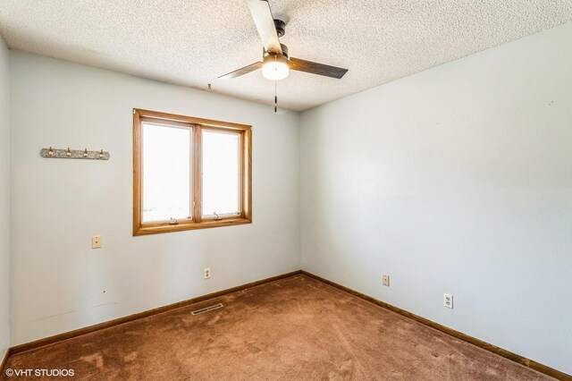 carpeted empty room featuring ceiling fan and a textured ceiling